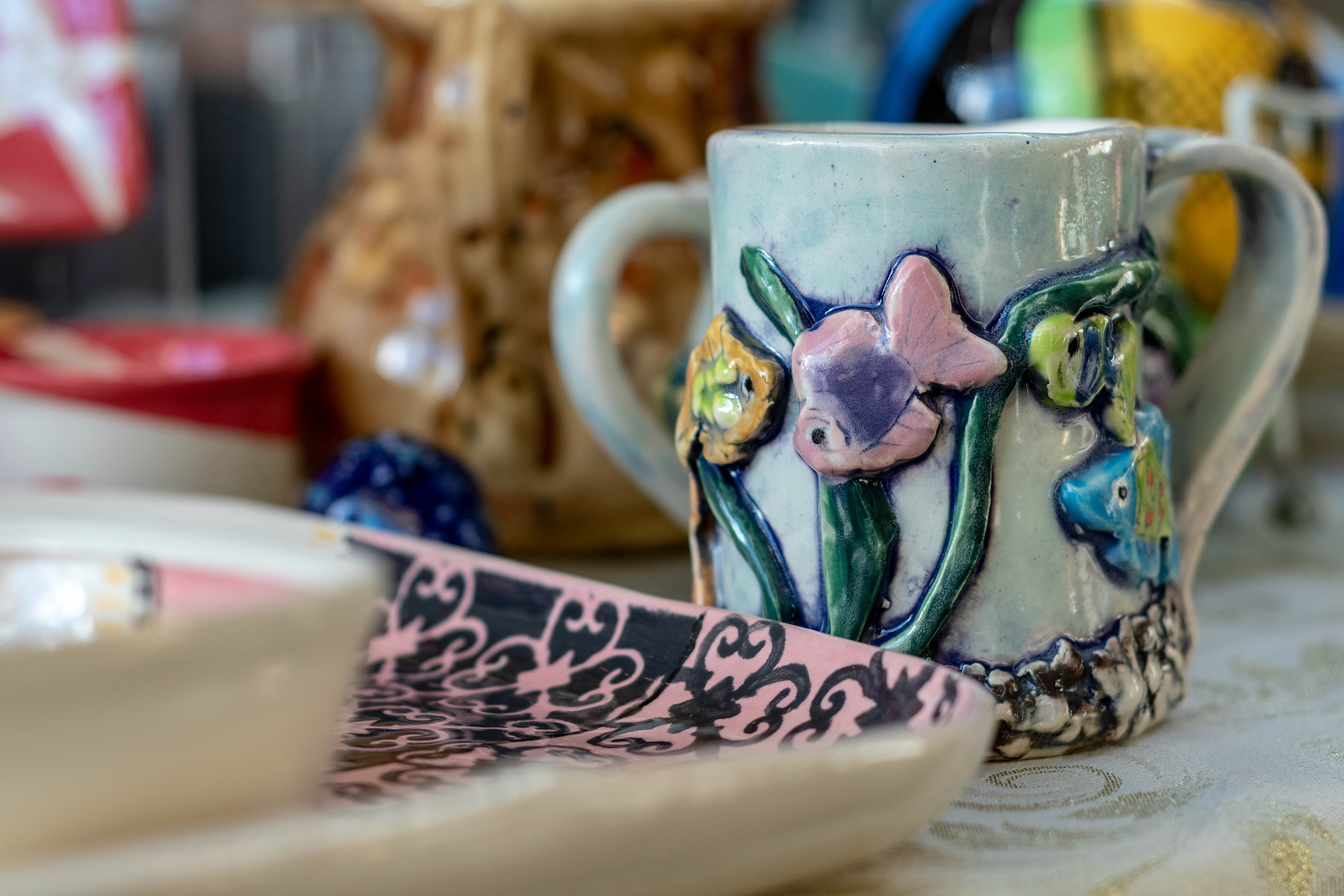 Mug with tropical clay fish, and decorative ceramic plate.