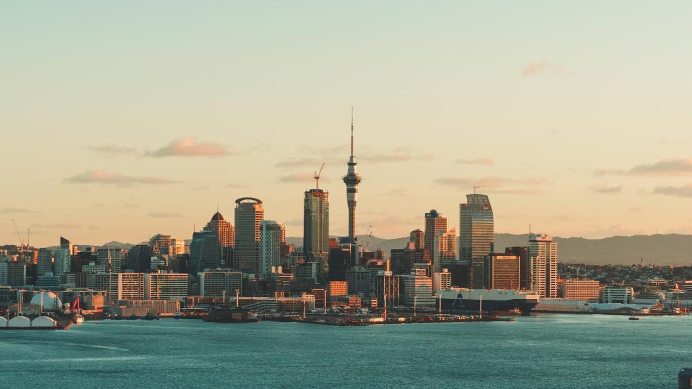 A view of downtown Auckland from across the ocean at dusk